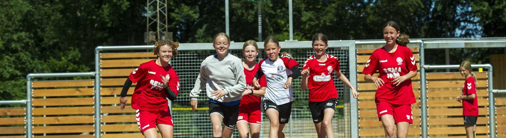 Voetbalmeisjes rennen naar een voetbal